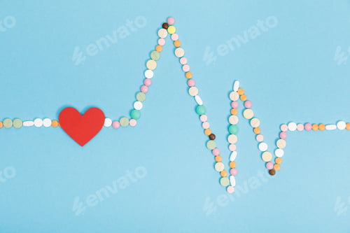 Preview: Flat lay with colorful pills and paper heart on blue