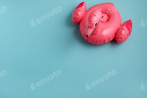 Preview: Inflatable flamingo pool float on blue background. Top view. Copy space