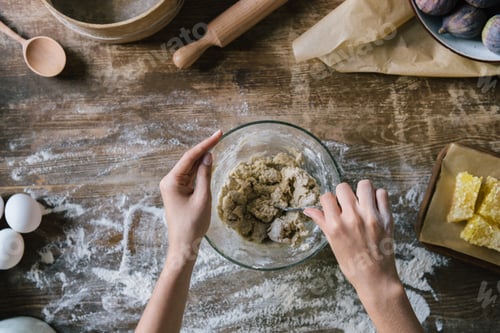 Preview: cropped shot of woman mixing dough in glass bowl with spoon on rustic wooden table