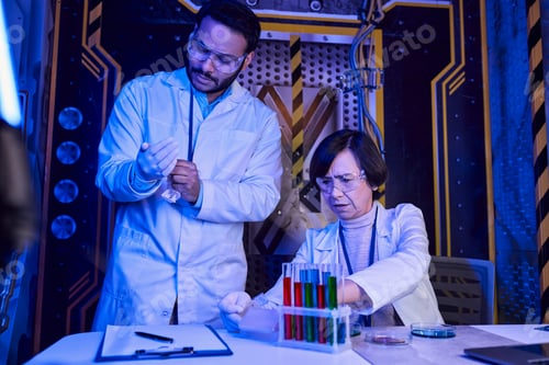 Preview: woman scientist working with samples of alien life near indian colleague, futuristic science center