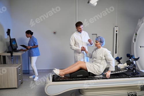 Preview: Caring healthcare team assists female patient before MRI scan in modern medical facility