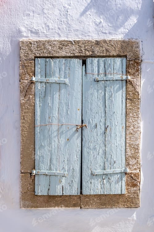 Preview: Window closed wood shutter on white wall. Cyclades house front view, Greek island architecture.