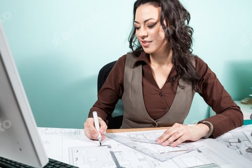 Preview: Woman at her office with blueprints in front of her