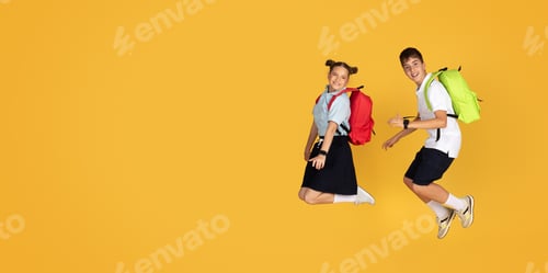 Preview: Glad caucasian teenager girl and boy with backpacks jumping, freeze in air, celebrate win, have fun