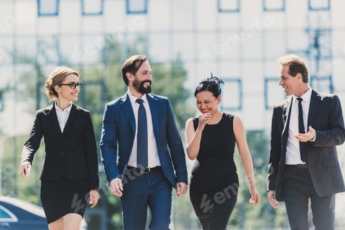 Preview: professional team of middle aged multiethnic businesspeople walking together and talking in city