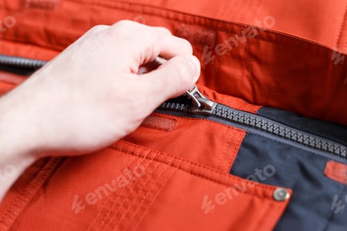 Preview: Part of a zipper with a lock on red cloth