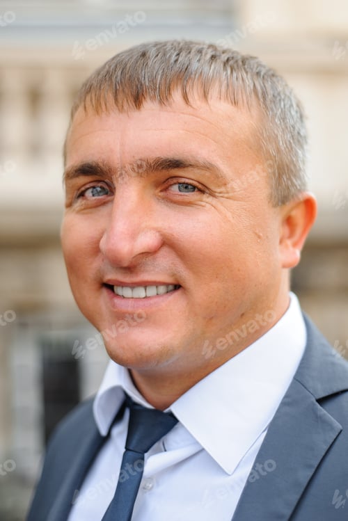 Preview: Close-up portrait of a businessman in a suit. The man is smiling.