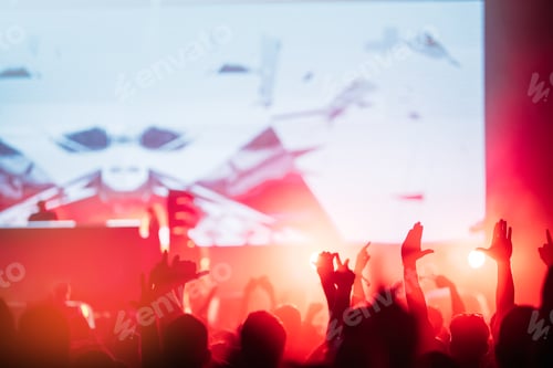 Preview: Cheering crowd with hands in air at music festival