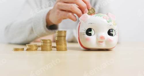 Preview: Putting golden coins into piggy bank at home