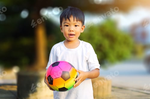 Preview: Happy Asian child boy playing with a ball. Sport and exercise for health.
