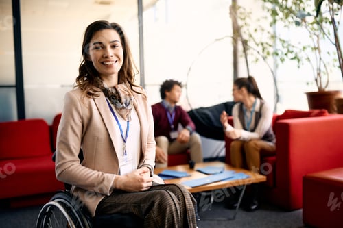 Preview: Portrait of happy businesswoman in wheelchair in the office looking at camera.