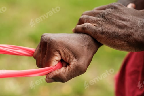 Preview: Farmer stretching red plastic in agricultural setting