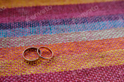 Preview: Two golden wedding rings on colourful fabric. Bridal accessories