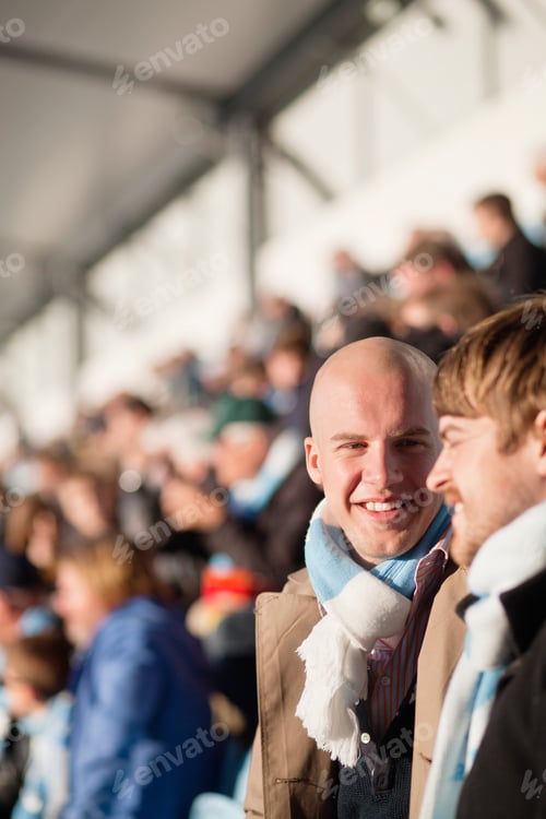 Preview: Happy bald man looking at friend in stadium on sunny day