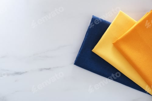 Preview: Colorful napkins on white marble table, top view. Space for text