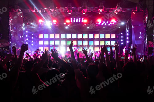 Preview: Silhouettes of crowd, group of people, cheering in live music concert in front of stage lights.