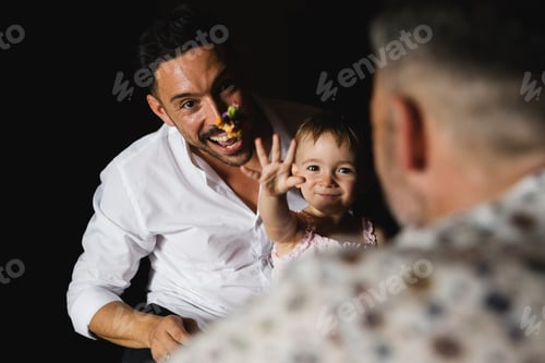 Preview: Happy gay couple playing with their little daughter at home