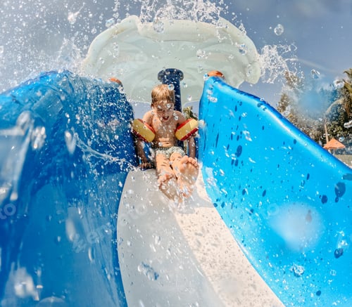 Preview: Little boy enjoying water slide during family vacation.