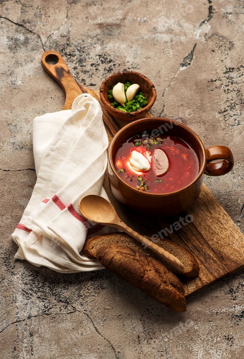 Preview: Traditional Russian borscht with bread and sour cream on the bowl.