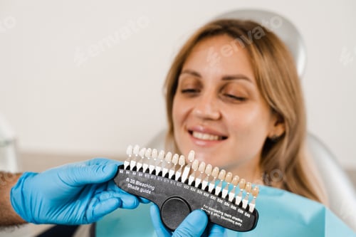 Preview: Woman reviewing tooth whitening shades with dentist using color matching guide