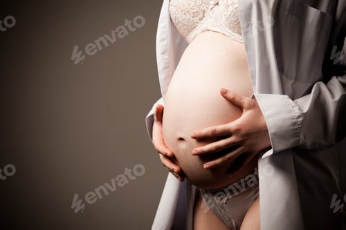 Preview: Pregnant woman holding hands on her belly