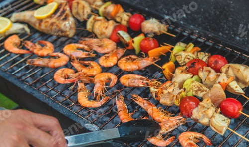 Preview: Shrimp, vegetables and fish are fried on a barbecue. Selective focus.