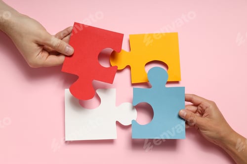 Preview: Puzzles and hands on pink background, top view