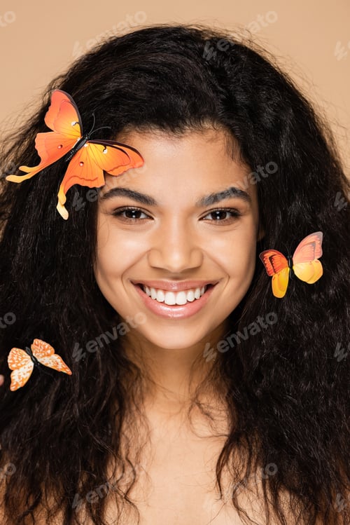 Preview: brunette african american woman with orange butterflies on hair isolated on beige