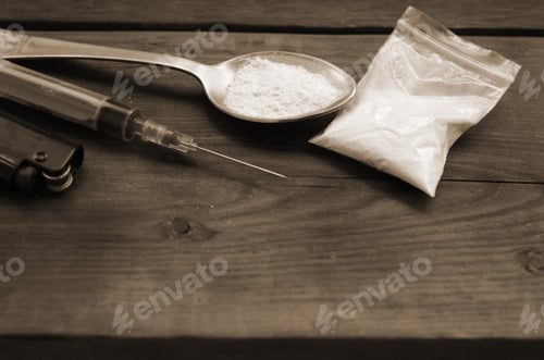 Preview: Syringe lighter and spoon full of white powder on wooden background. Heroin drug addiction concept