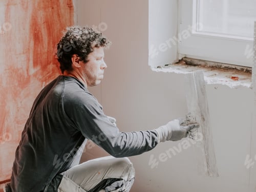 Preview: A young man is putting putty on the wall.