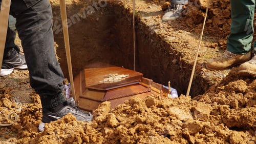 Preview: Burial. Men lower the coffin into the grave.