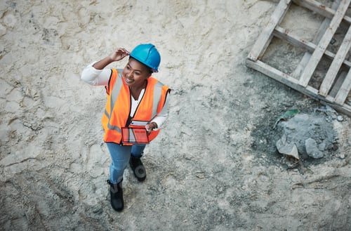 Preview: Shot of a young woman using a digital tablet while working at a construction site