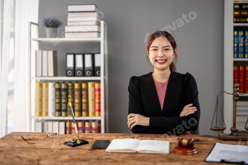 Preview: A woman is sitting at a desk in a room with a lot of books