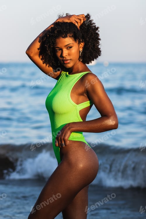 Preview: dreamy black woman standing in sea during summer vacation