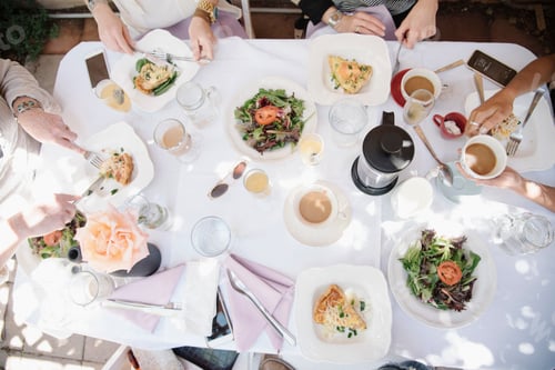 Preview: High angle view of four women sitting round a table with food and drink, plates with omelette and