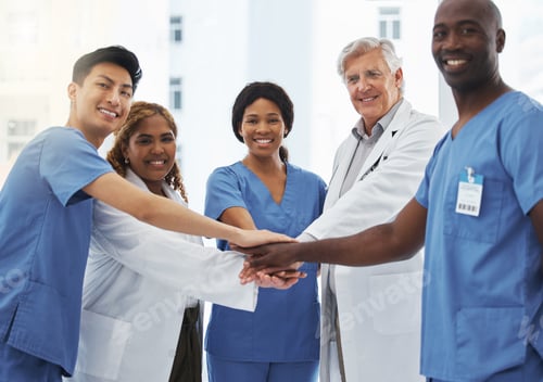 Preview: Portrait of a group of medical practitioners joining their hands together in a huddle in a hospital