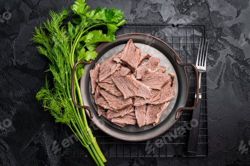 Preview: Boiled sliced beef meat in a steel tray. black background. top view