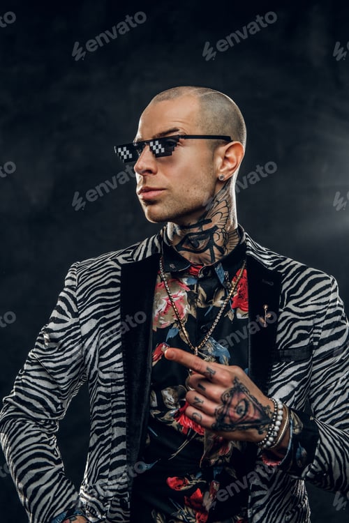Preview: Fashionable tattooed male model posing in a studio