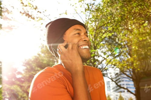 Preview: happy black guy talking with cellphone on sunny day