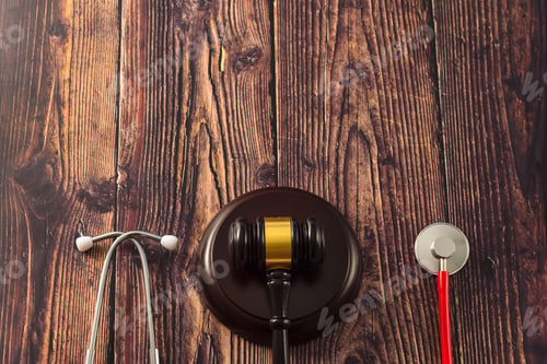 Preview: Gavel and stethoscope on wooden background, dark environment.