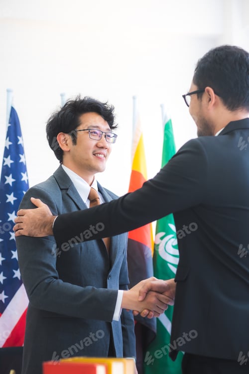 Preview: Business people shake hands, international flag background