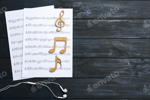 Preview: Flat lay composition with music notes, earphones and space for text on wooden background