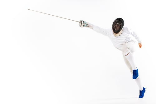 Preview: Man wearing fencing suit practicing with sword against gray