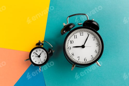 Preview: Vintage black alarm clock on a color block background
