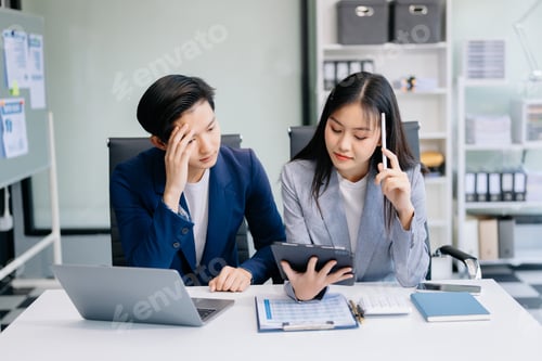Preview: Furious two Asian businesspeople arguing strongly after making a mistake at work in office