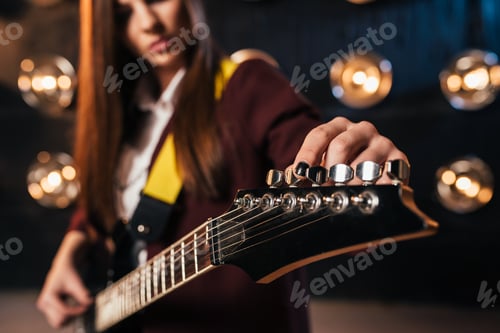 Preview: Female rock guitarist in suit tunes the guitar