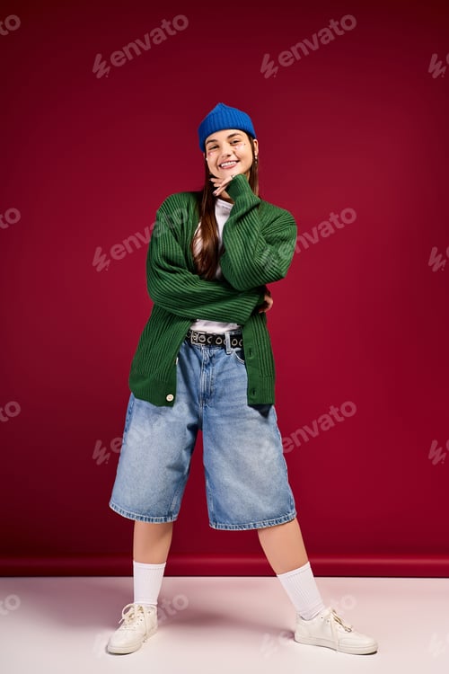 Preview: Teen girl flaunting trendy winter style against a vibrant red backdrop