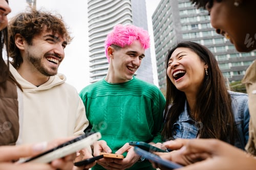 Preview: Diverse young friends having fun using mobile phones at city street