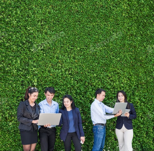 Preview: Businesswoman and businessman working outside office using laptop