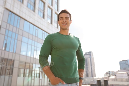 Preview: Portrait of handsome young African-American man on city street, low angle view